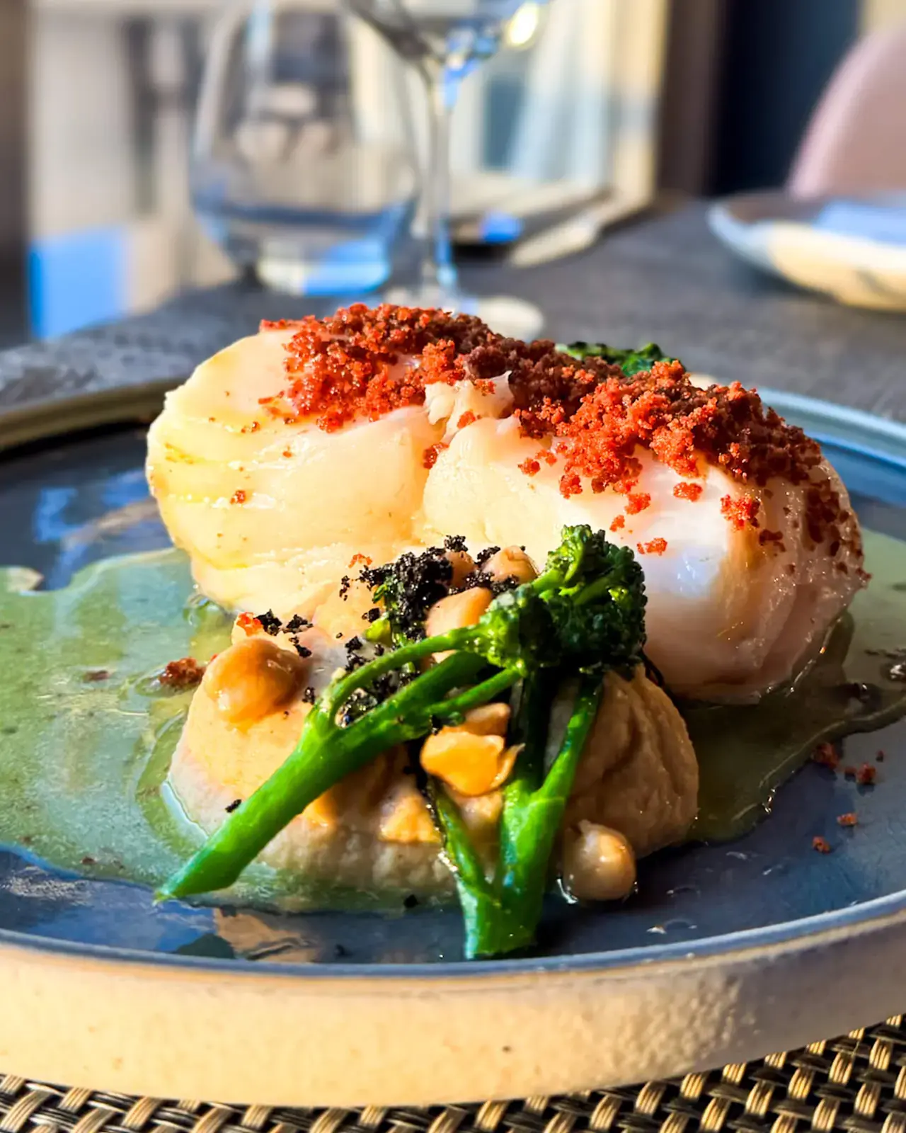 Lombo de bacalhau com crumble avermelhado sobre puré de grão e brócolos